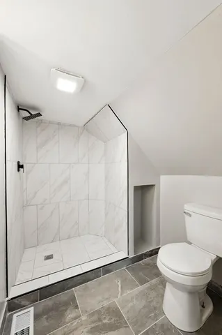 a view of an empty room with wooden floor and window