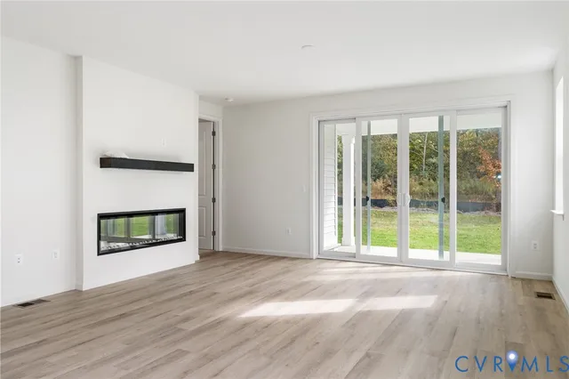 a view of an empty room with a fireplace and a window