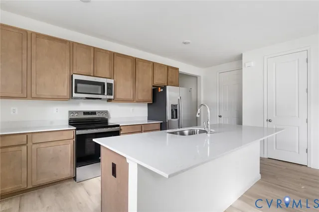 a kitchen with kitchen island a sink stove and refrigerator