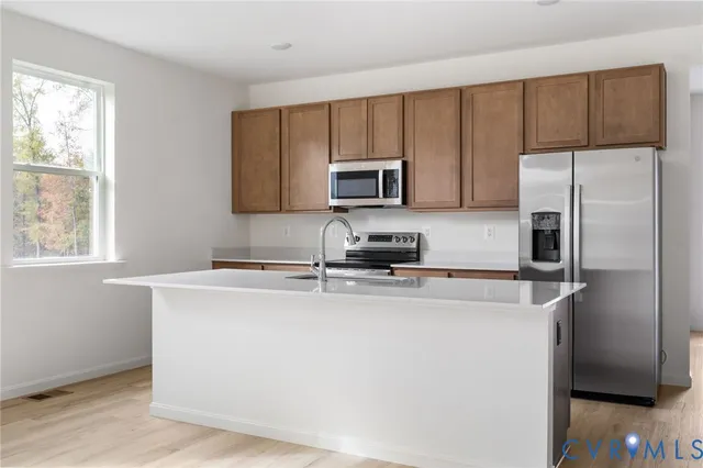 a kitchen with a refrigerator a microwave a sink and cabinets