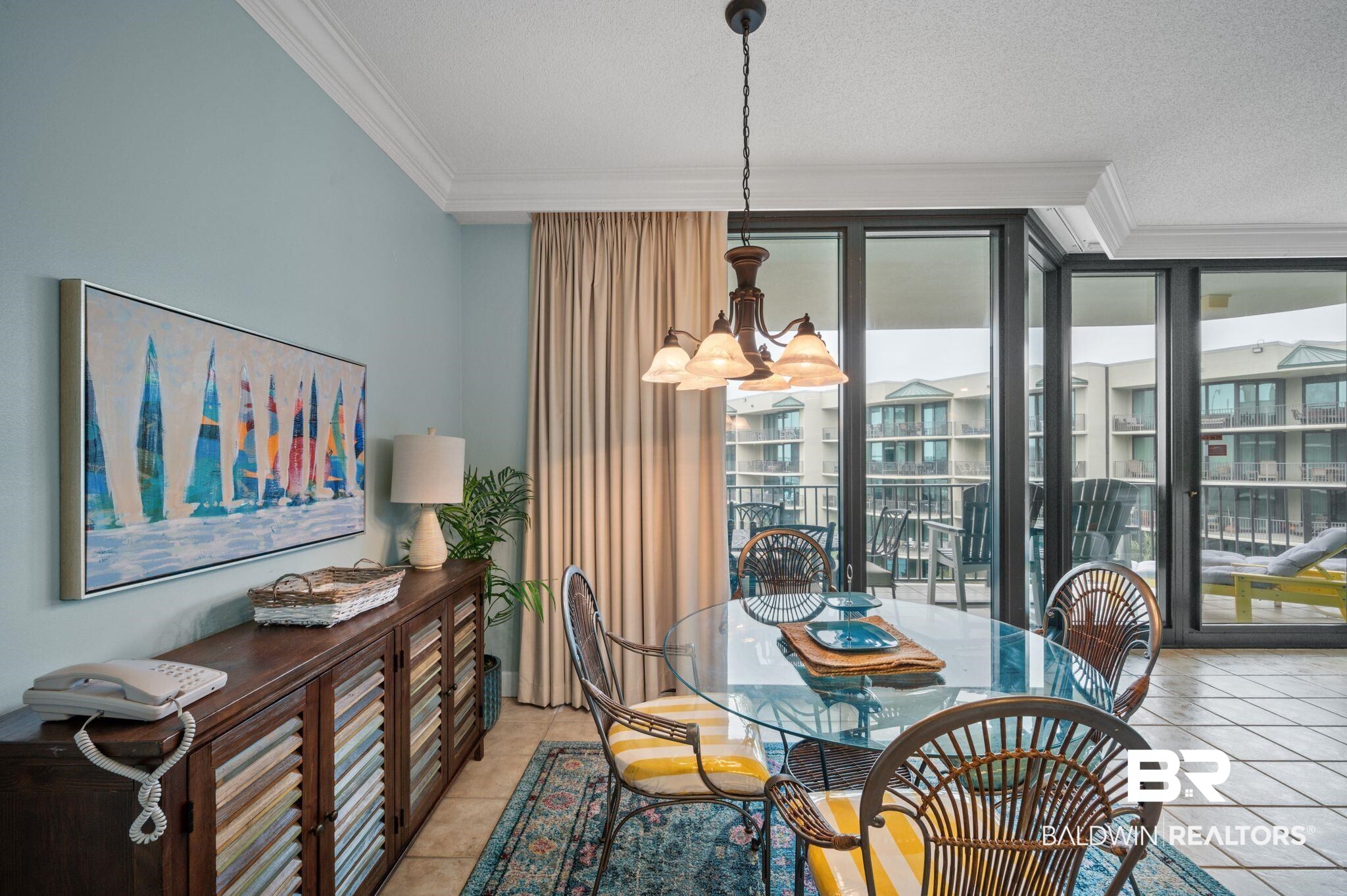 27580 Canal Road, Unit 1427 Orange Beach, AL 36561 - Photo 11 of 38 Dining space with a chandelier, crown molding, floor to ceiling windows, a textured ceiling, and light tile patterned flooring