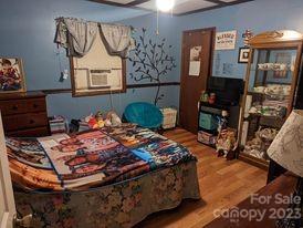 180 Sunset Drive Rutherfordton, NC 28139 - Photo 16 of 44 a bed sitting in a bedroom next to a window with pc on the table