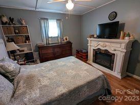 180 Sunset Drive Rutherfordton, NC 28139 - Photo 18 of 44 a bedroom with a bed and a fireplace