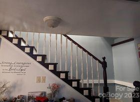 180 Sunset Drive Rutherfordton, NC 28139 - Photo 25 of 44 a view of staircase with lots of frames on wall and wooden floor