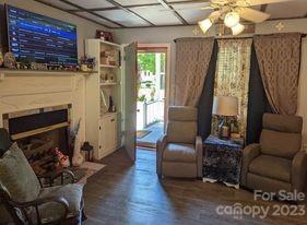 180 Sunset Drive Rutherfordton, NC 28139 - Photo 3 of 44 a living room with furniture a fireplace and a flat screen tv
