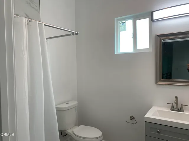 a bathroom with a toilet a sink and a mirror
