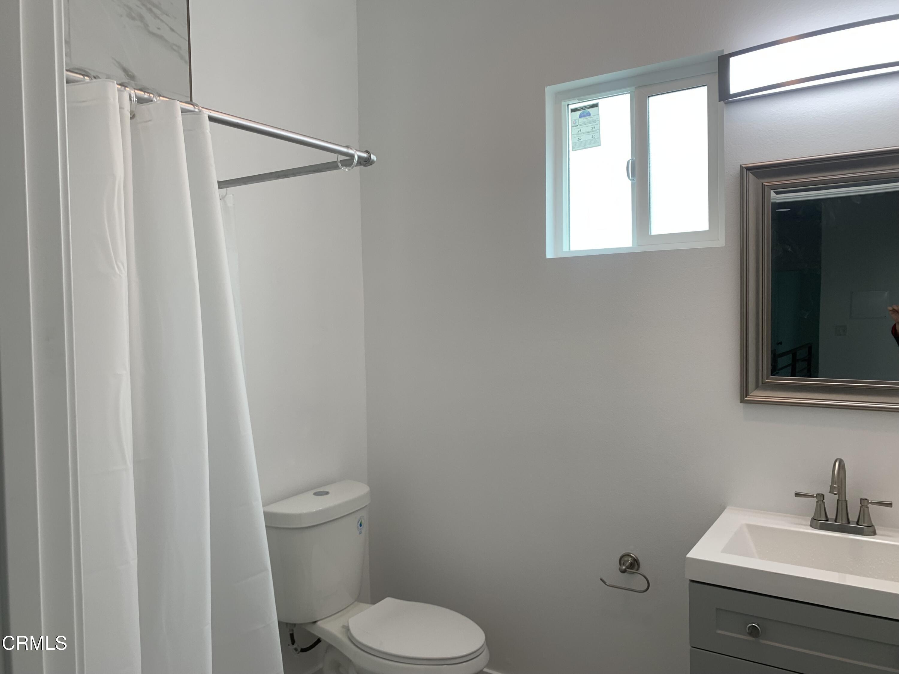6375 Converse Avenue, Unit A Los Angeles, CA 90001 - Photo 12 of 14 a bathroom with a toilet a sink and a mirror