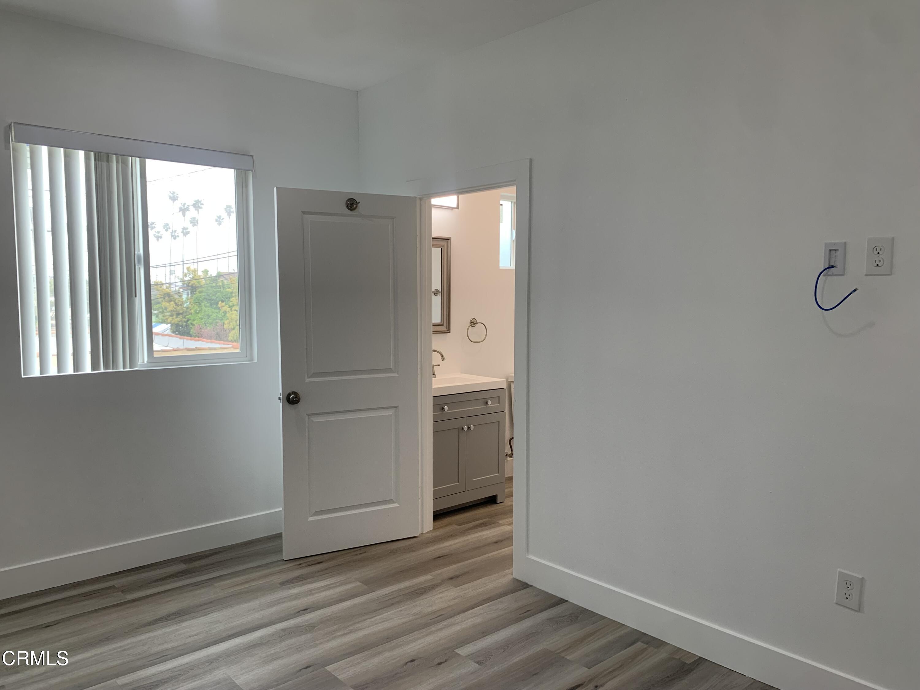 6375 Converse Avenue, Unit A Los Angeles, CA 90001 - Photo 8 of 14 an empty room with wooden floor cabinet and windows