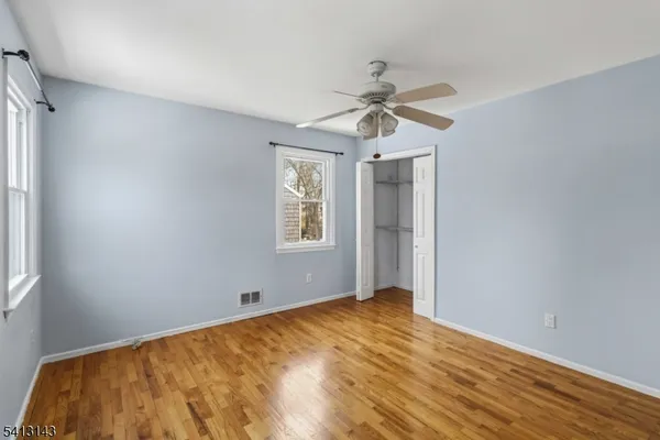 a view of a room with a window and wooden floor