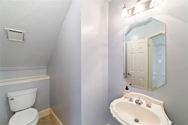 a bathroom with a toilet sink and mirror