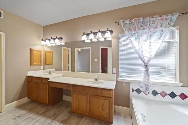 a spacious bathroom with a sink a large mirror and a bathtub