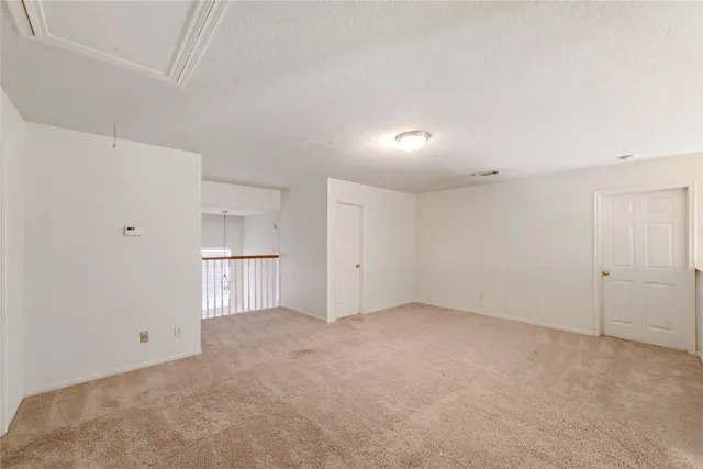 an empty room with wooden floor closet and fan