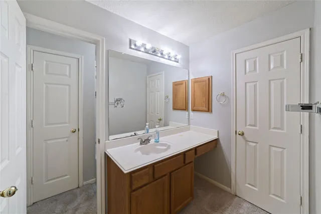 a view of an empty room with chandelier fan