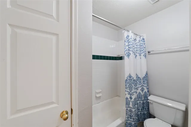 a view of an empty room with a chandelier fan