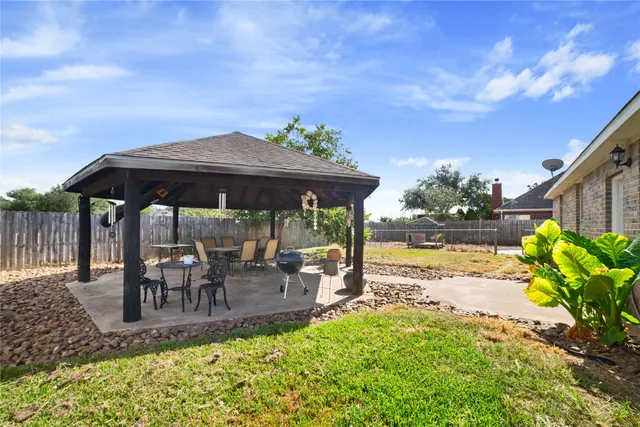 a backyard of a house with table and chairs