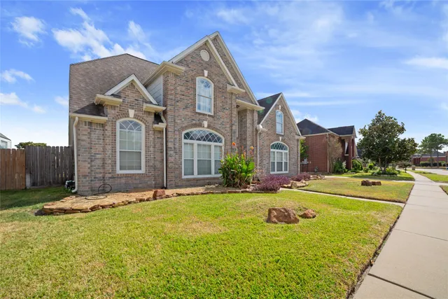 a front view of house with yard and trees in the background