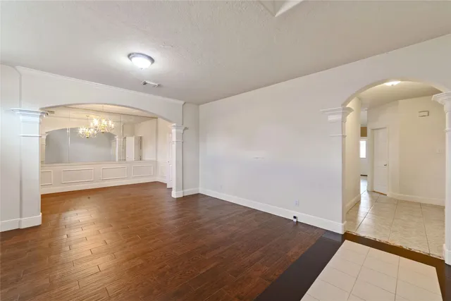 an empty room with wooden floor and door