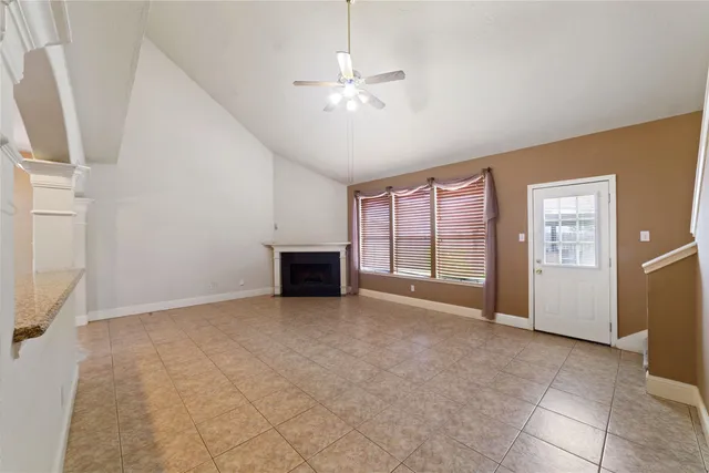 an empty room with windows and fireplace