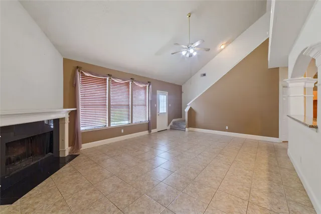 a view of an empty room with a fireplace and a window