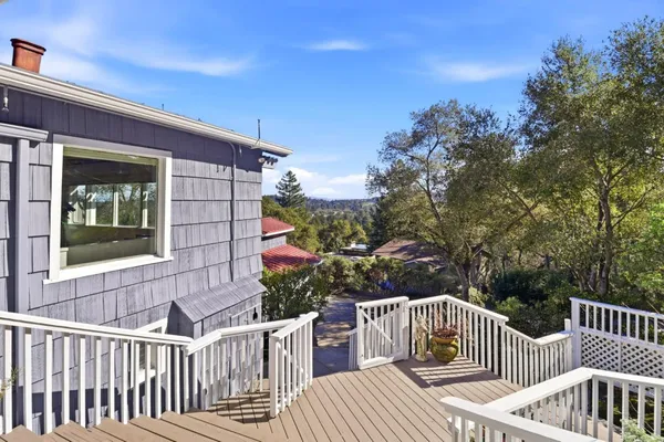 a view of deck with two chairs and wooden fence