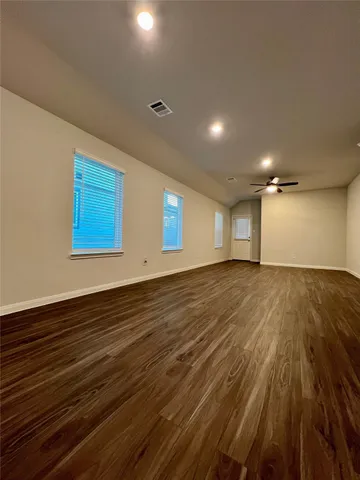 a view of an empty room with wooden floor