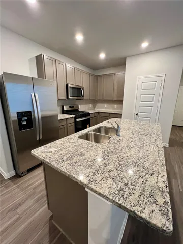 a kitchen with stainless steel appliances granite countertop a sink refrigerator and microwave