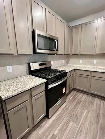 a kitchen with granite countertop wooden cabinets and a sink