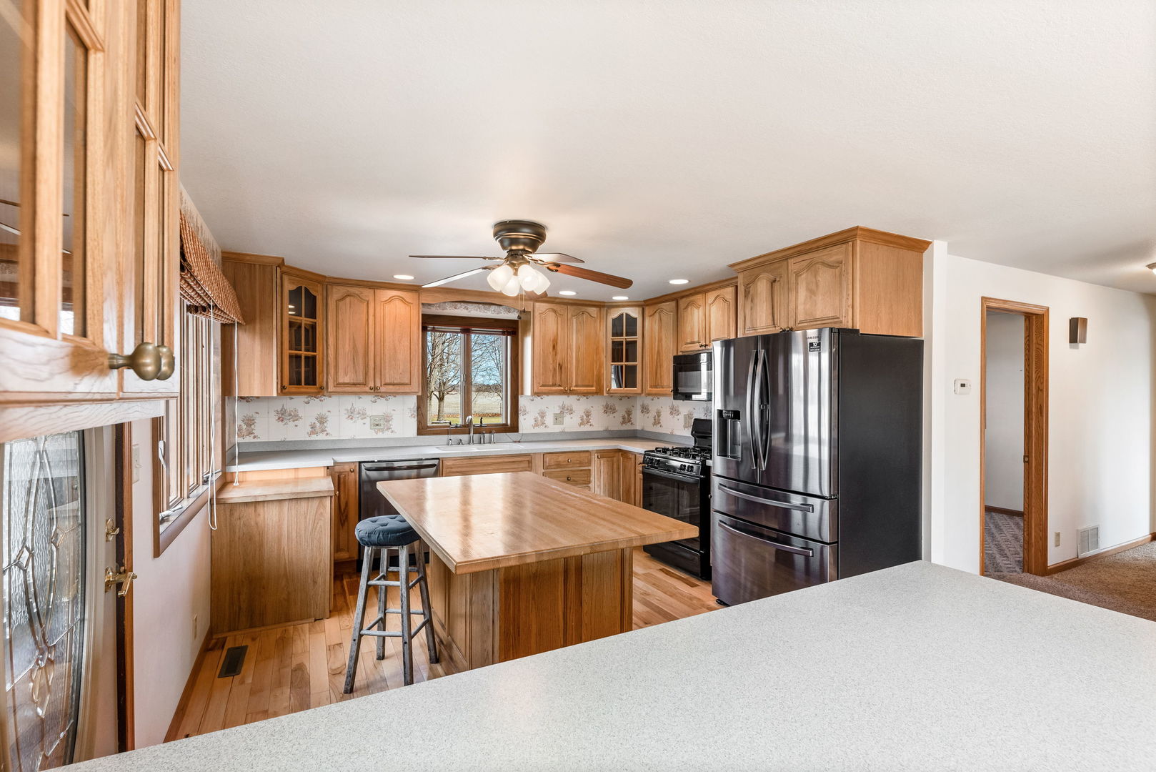 531 South Hieland Road St. Anne, IL 60964 - Photo 7 of 45 a kitchen with stainless steel appliances granite countertop a refrigerator a stove a sink a dining table and chairs with wooden floor