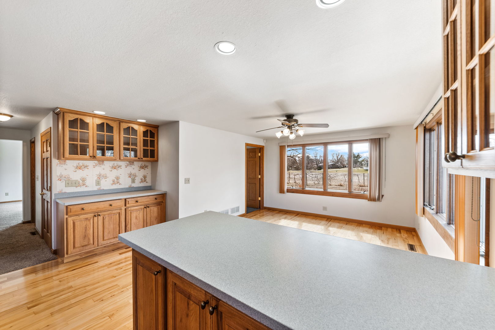 531 South Hieland Road St. Anne, IL 60964 - Photo 8 of 45 a hall with kitchen island a stove a wooden floor and a sink
