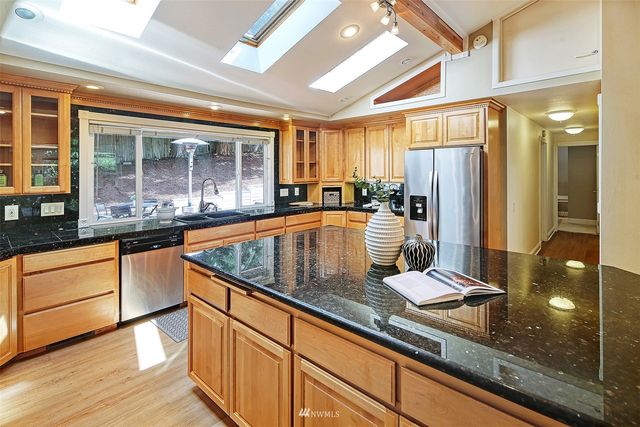 a kitchen with granite countertop a sink and a refrigerator