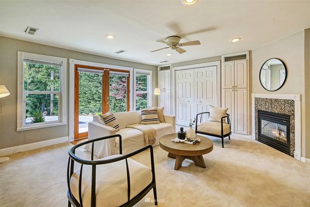 a living room with furniture a fireplace and a large window