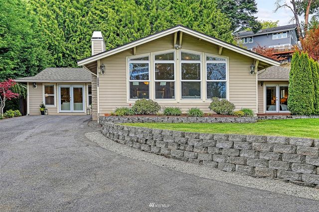 a front view of a house with a yard and potted plants