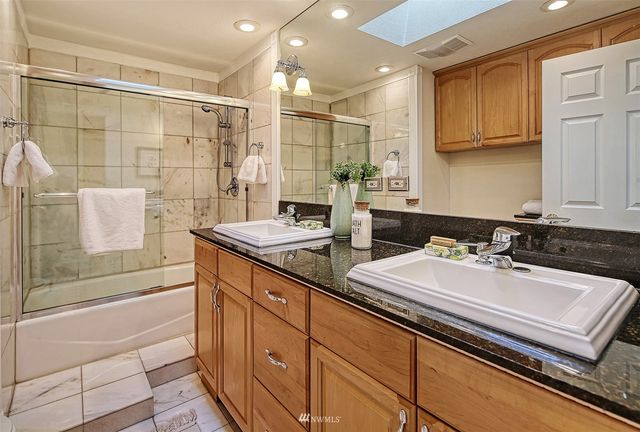 a bathroom with a double vanity sink a mirror and a bathtub