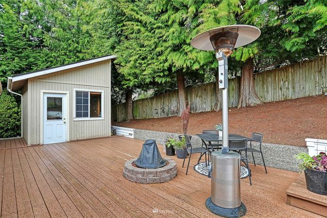 a backyard of a house with table and chairs potted plants