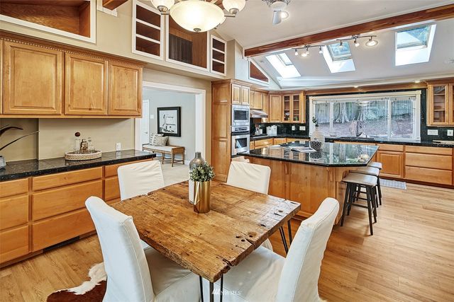 a dining room with stainless steel appliances granite countertop a dining table and chairs