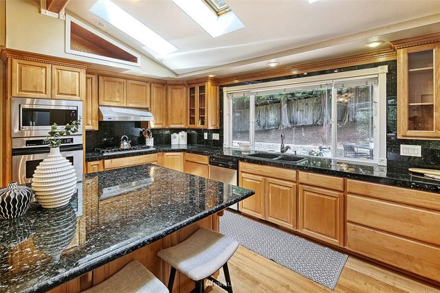 a kitchen with stainless steel appliances granite countertop a stove and a sink