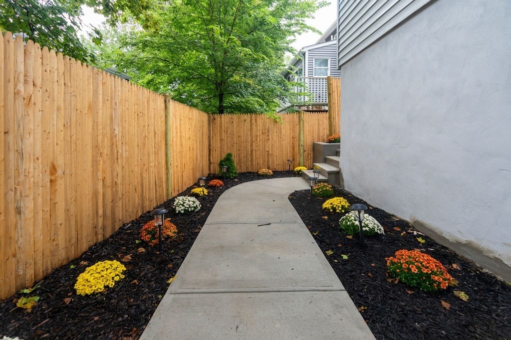 9-13 Sutherland Road, Unit 2 Arlington, MA 02476 - Photo 11 of 15 a view of a backyard with table and chairs and potted plants