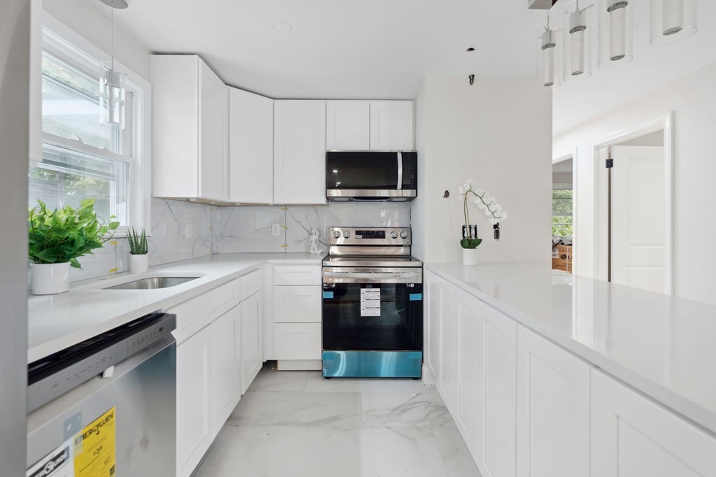 9-13 Sutherland Road, Unit 2 Arlington, MA 02476 - Photo 4 of 15 a kitchen with stainless steel appliances granite countertop a stove a sink and a refrigerator