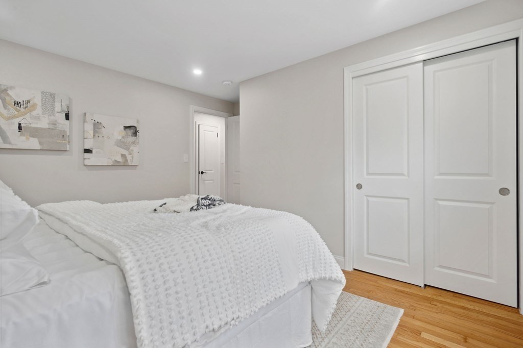 9-13 Sutherland Road, Unit 2 Arlington, MA 02476 - Photo 8 of 15 a bed room with a bed and a wooden floor