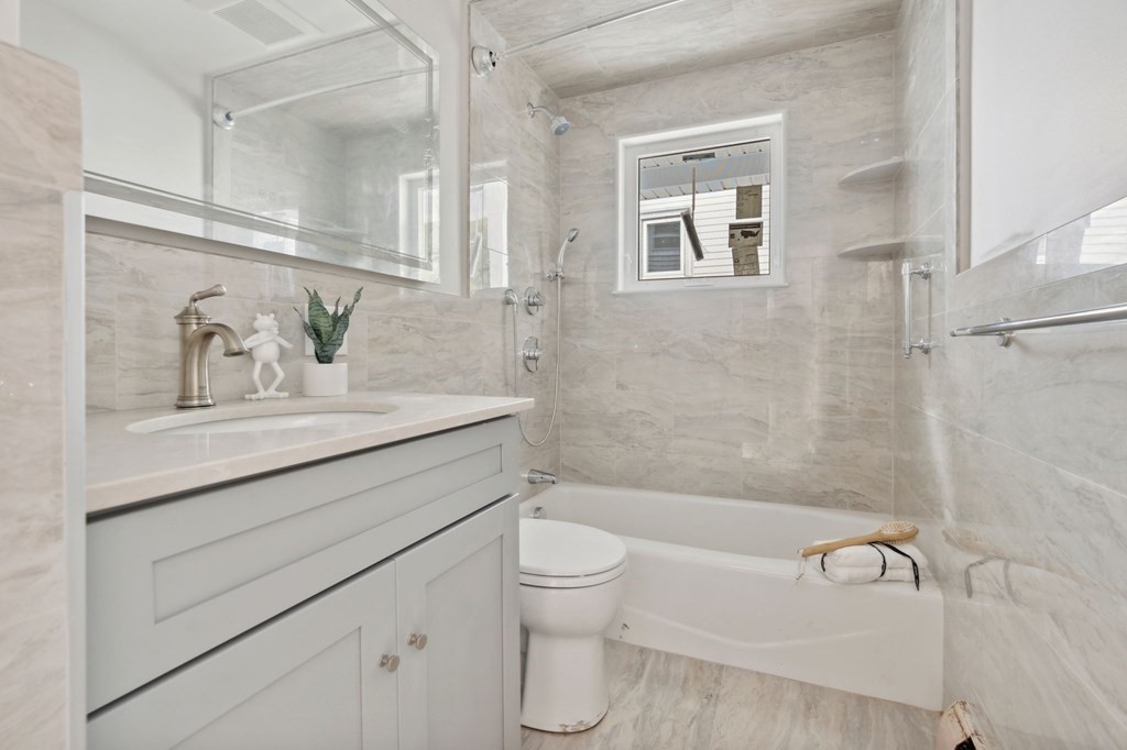9-13 Sutherland Road, Unit 2 Arlington, MA 02476 - Photo 9 of 15 a bathroom with a sink a toilet and shower
