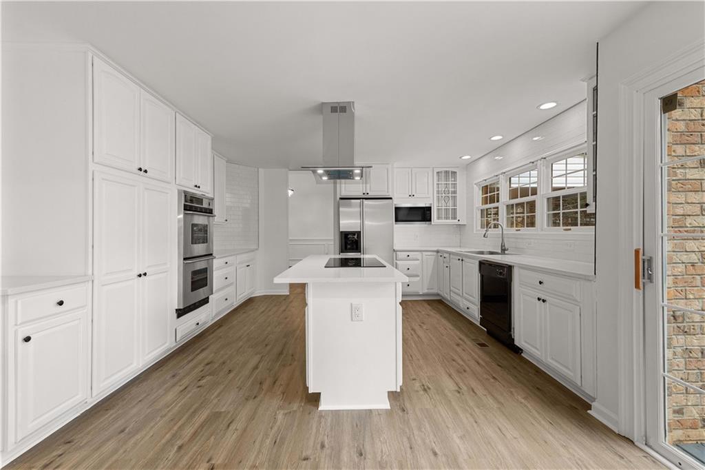 5302 Greenway Drive Villa Rica, GA 30180 - Photo 13 of 79 a kitchen with stainless steel appliances a stove top oven a sink a refrigerator and white cabinets with wooden floor