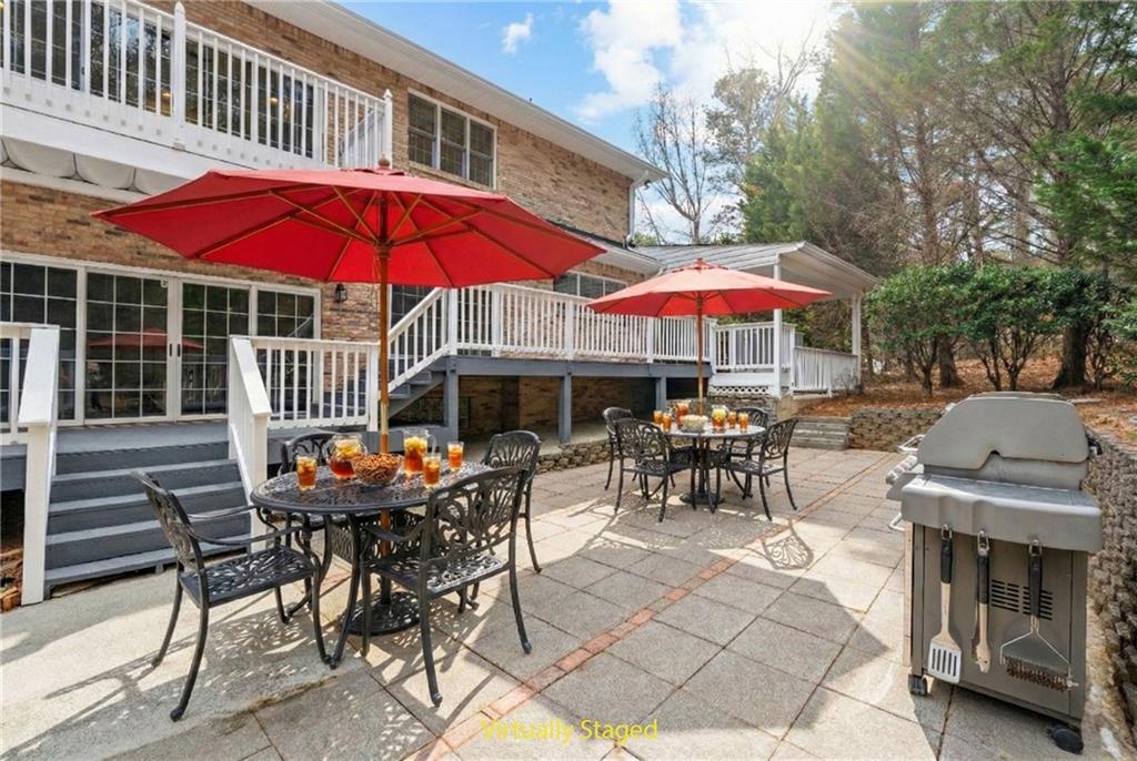 5302 Greenway Drive Villa Rica, GA 30180 - Photo 62 of 81 a patio with a table and chairs under an umbrella