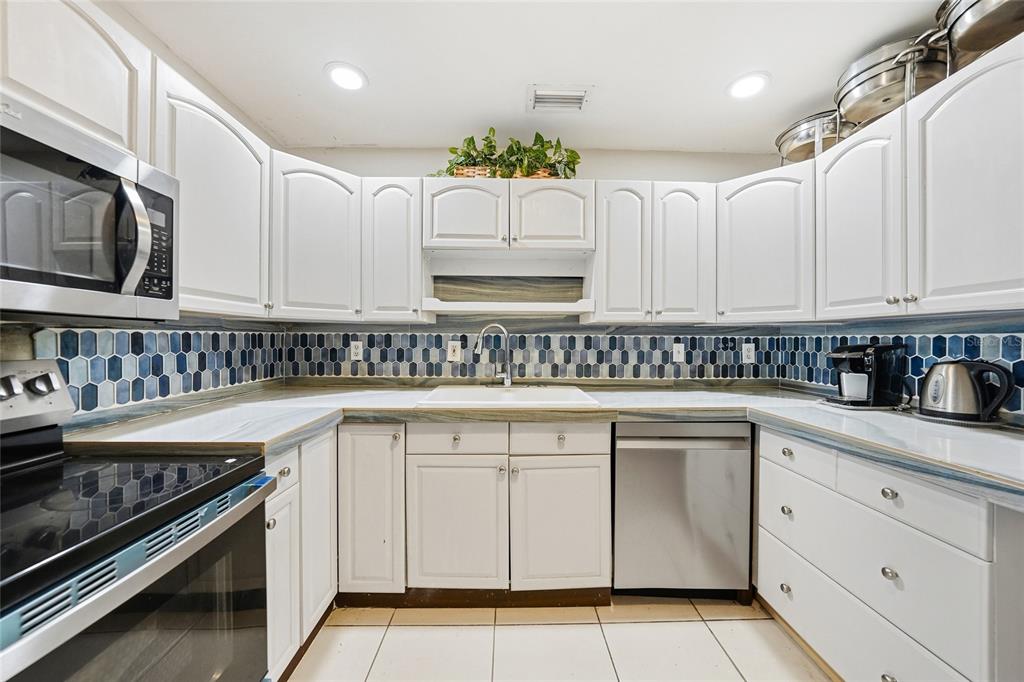 2930 Acline Road Punta Gorda, FL 33950 - Photo 6 of 29 a kitchen with granite countertop white cabinets and white appliances
