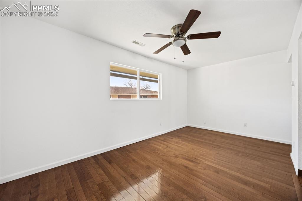 2131 Preuss Road, Unit A Colorado Springs, CO 80910 - Photo 5 of 17 an empty room with wooden floor fan and windows