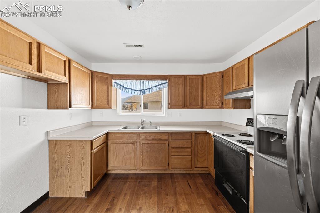 2131 Preuss Road, Unit A Colorado Springs, CO 80910 - Photo 8 of 17 a kitchen with stainless steel appliances granite countertop a sink stove and refrigerator