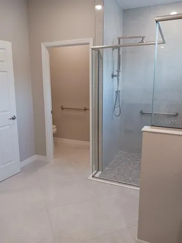 a bathroom with a granite countertop double vanity sink and mirror