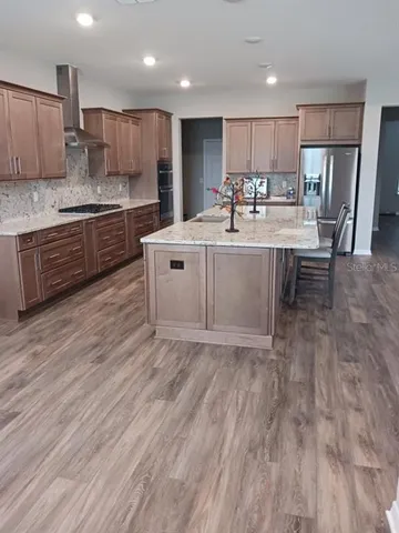 a kitchen with stainless steel appliances wooden floor sink and wooden cabinets