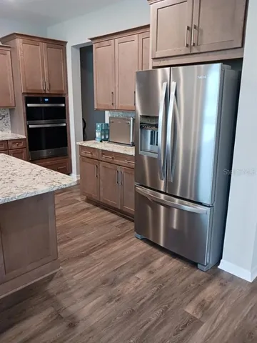 a kitchen with a sink and wooden floor