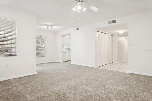 an empty room with fan and windows