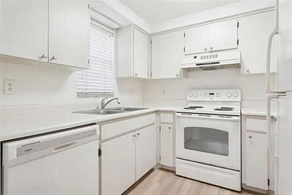 a kitchen with stainless steel appliances white cabinets and a sink